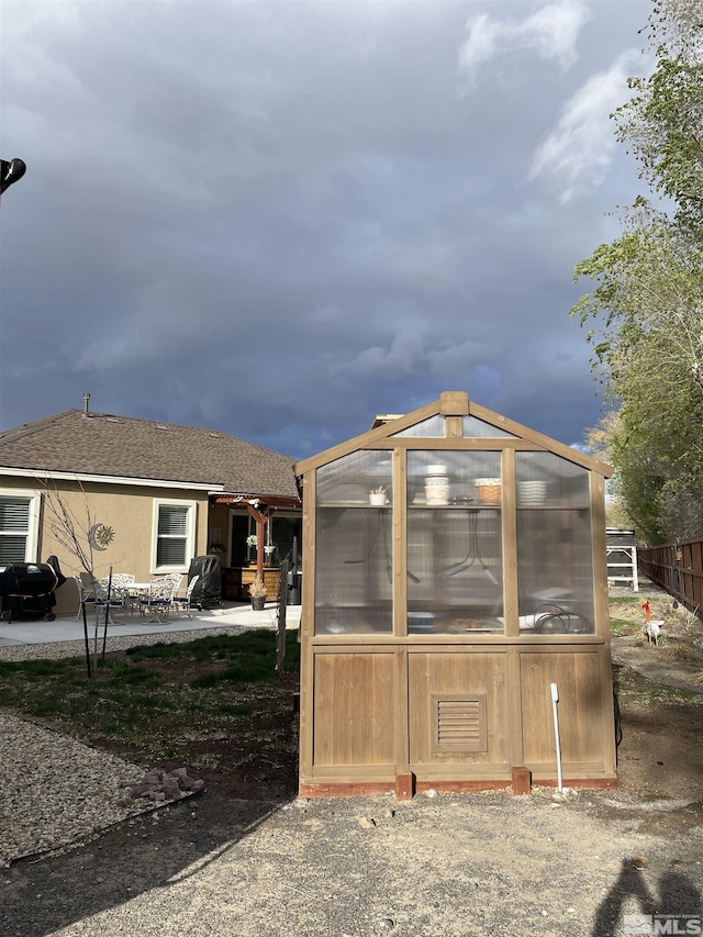 684 Rose Ln, Fernley, NV 89408 - back of property featuring an exterior structure, an outdoor structure, a patio area, and fence