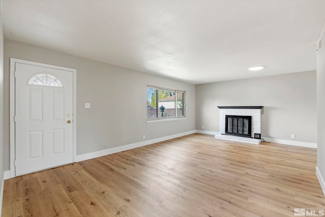 1365 Prospect Ave, Sparks, NV 89431 - unfurnished living room with light wood finished floors, baseboards, and a brick fireplace