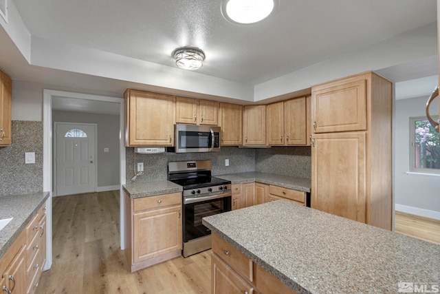 1365 Prospect Ave, Sparks, NV 89431 - kitchen with appliances with stainless steel finishes, backsplash, light wood-style floors, and baseboards