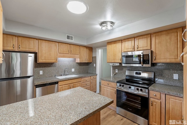 1365 Prospect Ave, Sparks, NV 89431 - kitchen with stainless steel appliances, a sink, light wood-type flooring, and backsplash