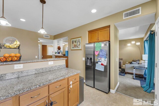 4889 Bougainvillea Cir, Sparks, NV 89436 - kitchen with stainless steel refrigerator with ice dispenser, pendant lighting, light stone countertops, recessed lighting, and brown cabinets
