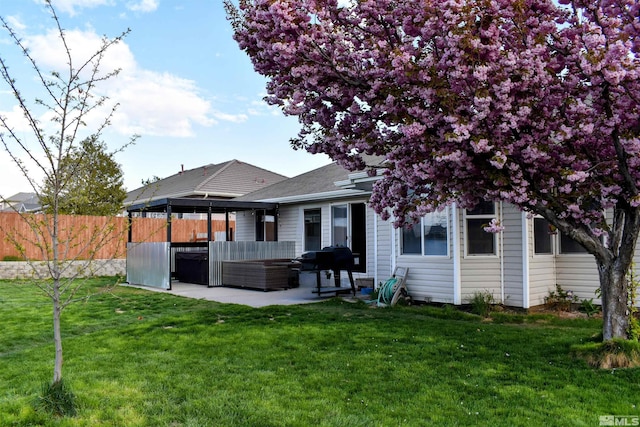 rear view of property featuring a patio, an outdoor living space, and a shingled roof