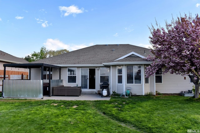 rear view of property featuring a patio, outdoor lounge area, a lawn, and a shingled roof