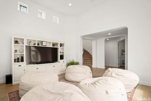 10198 Via Como, Reno, NV 89511 - living area featuring stairs, light wood finished floors, baseboards, recessed lighting, and a towering ceiling