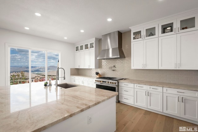 10198 Via Como, Reno, NV 89511 - kitchen featuring wall chimney range hood, a sink, double oven range, white cabinetry, and recessed lighting