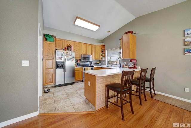 2120 Keystone Ave, Reno, NV 89503 - kitchen featuring appliances with stainless steel finishes, lofted ceiling, a peninsula, open shelves, and light countertops