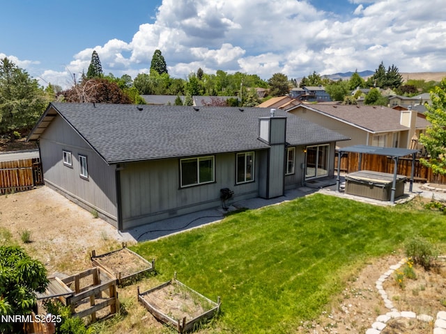 2120 Keystone Ave, Reno, NV 89503 - back of property featuring a hot tub, a shingled roof, a fenced backyard, a patio area, and a vegetable garden