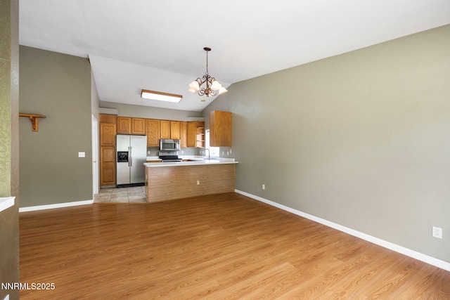 2120 Keystone Ave, Reno, NV 89503 - kitchen with stainless steel appliances, light wood-style floors, a chandelier, brown cabinets, and vaulted ceiling