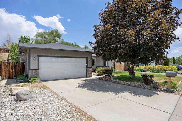 2120 Keystone Ave, Reno, NV 89503 - view of front of house featuring stone siding, an attached garage, and driveway