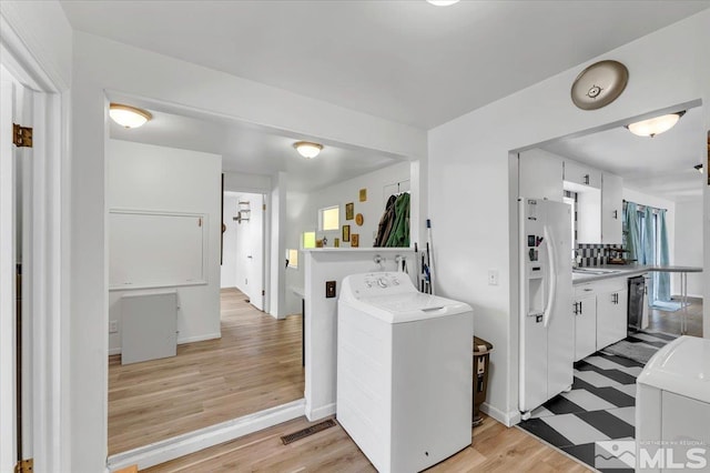 445 S Bailey, Fallon, NV 89406 - kitchen with washer / dryer, white refrigerator with ice dispenser, black dishwasher, white cabinets, and light countertops