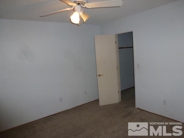 4650 Rio Poco Rd, Reno, NV 89502 - unfurnished bedroom featuring carpet, a walk in closet, and ceiling fan