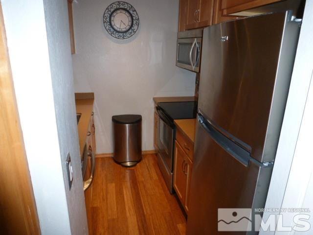 4650 Rio Poco Rd, Reno, NV 89502 - kitchen with appliances with stainless steel finishes, light wood-style flooring, and brown cabinets