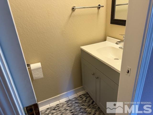 6700 Sandia Dr, Reno, NV 89523 - bathroom featuring tile patterned flooring, vanity, a textured wall, and baseboards