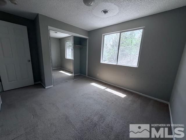 6700 Sandia Dr, Reno, NV 89523 - unfurnished bedroom with carpet floors, a closet, baseboards, and a textured ceiling