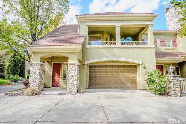 9900 Wilbur May Unit 3403, Reno, NV 89521 - view of front of house featuring a balcony, stucco siding, driveway, and stone siding