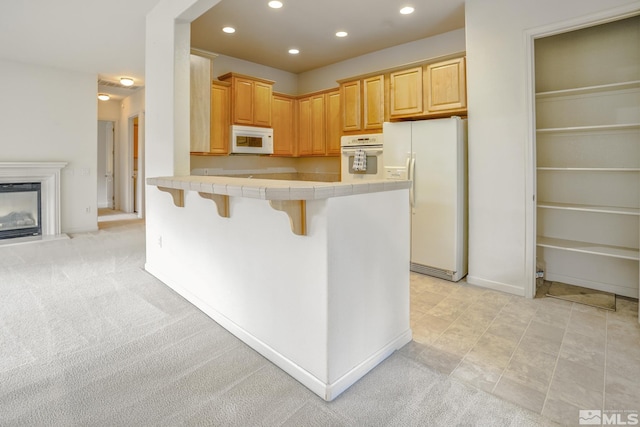 9900 Wilbur May Unit 3403, Reno, NV 89521 - kitchen with white appliances, tile countertops, recessed lighting, a kitchen bar, and a peninsula