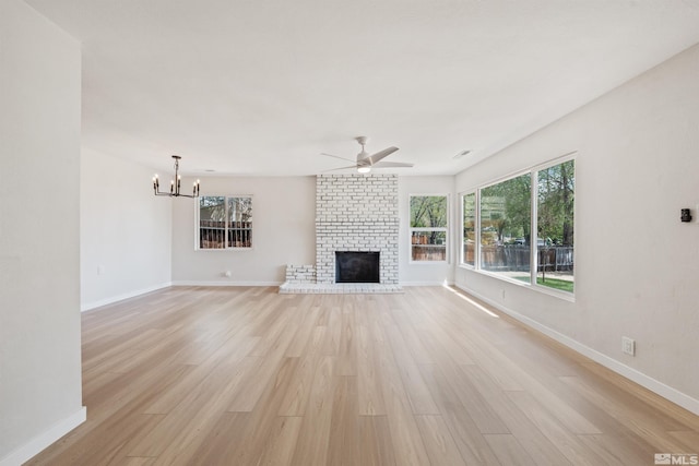 983 Melba Dr, Reno, NV 89503 - unfurnished living room with light wood-type flooring, a ceiling fan, a chandelier, a fireplace, and baseboards