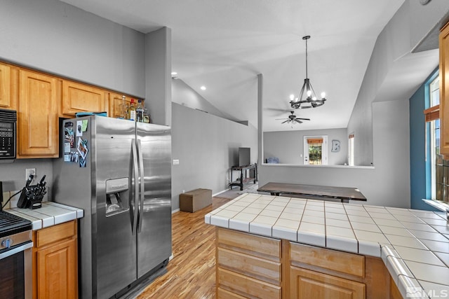 1359 Whooping Crane Dr, Sparks, NV 89441 - kitchen featuring appliances with stainless steel finishes, a chandelier, tile countertops, lofted ceiling, and light wood-type flooring