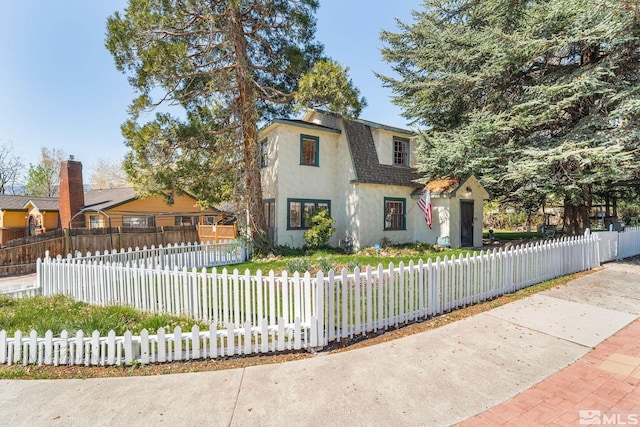 view of front facade with stucco siding and a fenced front yard