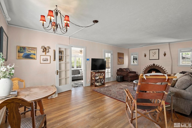 living room with light wood-style floors, a chandelier, and a textured ceiling
