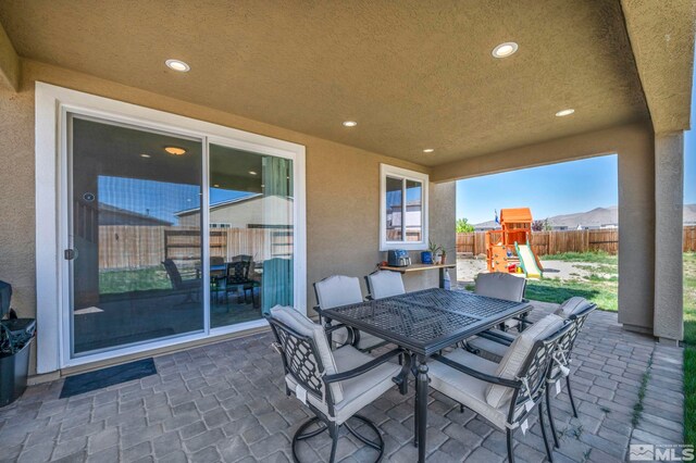 7836 Tarkio Ct, Sparks, NV 89436 - view of patio featuring fence, a playground, and outdoor dining area