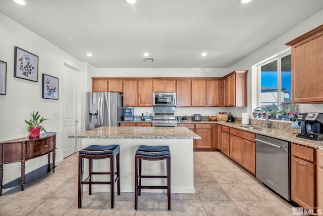7836 Tarkio Ct, Sparks, NV 89436 - kitchen featuring stainless steel appliances, a sink, brown cabinets, a center island, and a breakfast bar
