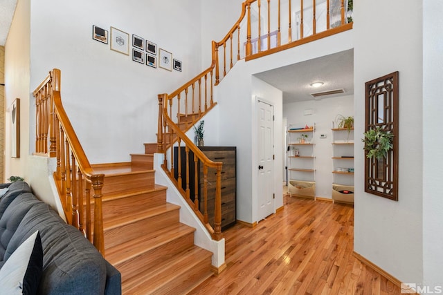 5276 Simons Dr, Reno, NV 89523 - staircase featuring a high ceiling, wood finished floors, and baseboards