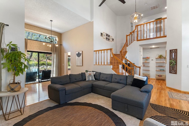 5276 Simons Dr, Reno, NV 89523 - living area with a towering ceiling, a chandelier, wood finished floors, stairs, and ceiling fan