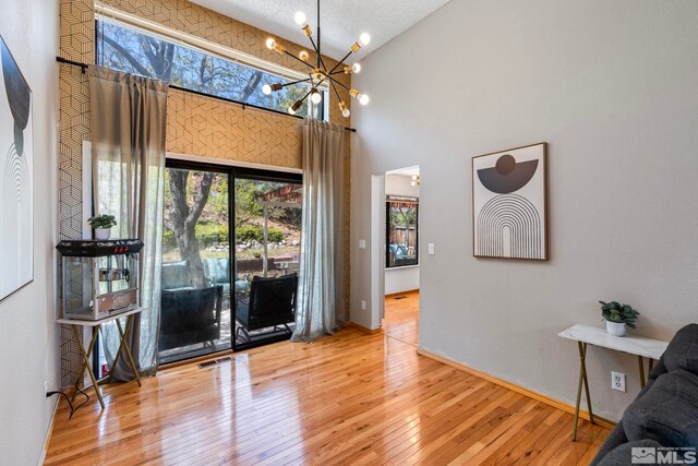 5276 Simons Dr, Reno, NV 89523 - dining space featuring a chandelier, wood-type flooring, high vaulted ceiling, and baseboards
