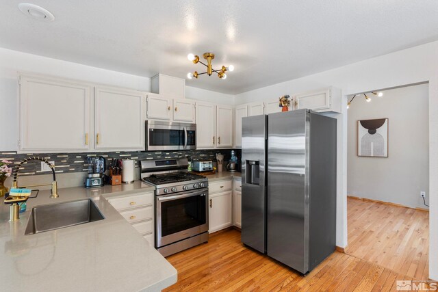 5276 Simons Dr, Reno, NV 89523 - kitchen with stainless steel appliances, a sink, light countertops, tasteful backsplash, and light wood-style flooring