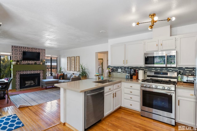 5276 Simons Dr, Reno, NV 89523 - kitchen with appliances with stainless steel finishes, a sink, open floor plan, a peninsula, and backsplash