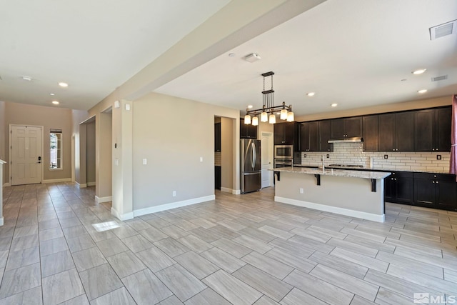 1680 Verdi Vista Ct, Reno, NV 89523 - kitchen featuring appliances with stainless steel finishes, a kitchen breakfast bar, tasteful backsplash, open floor plan, and light stone countertops
