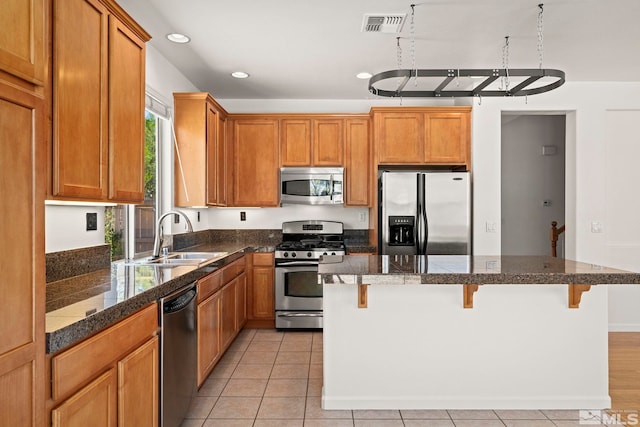 10655 Birch Point Ct, Reno, NV 89521 - kitchen with appliances with stainless steel finishes, a sink, a breakfast bar, a kitchen island, and recessed lighting