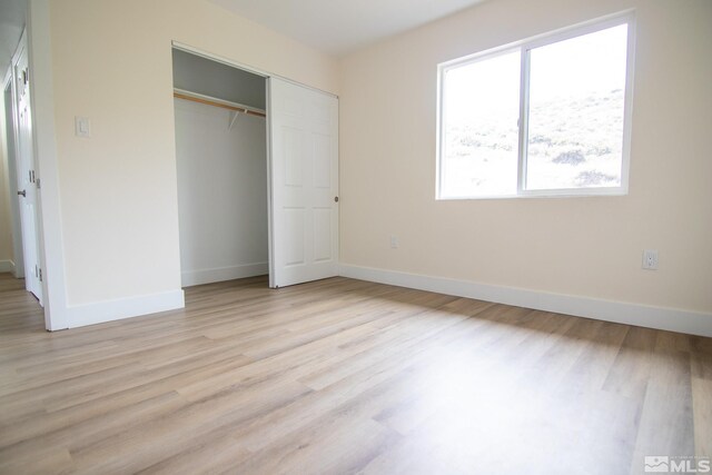 100 Bisset Ct Unit B, Reno, NV 89503 - unfurnished bedroom with light wood-style floors, baseboards, and a closet