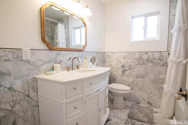 100 Bisset Ct Unit B, Reno, NV 89503 - full bath with tile walls, vanity, a wainscoted wall, marble finish flooring, and toilet