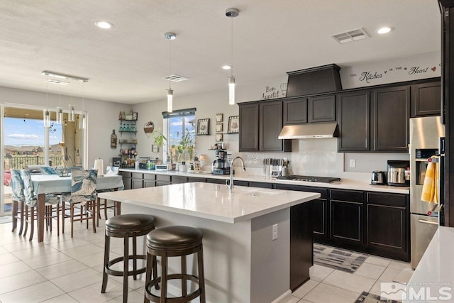 2449 Butte Creek Dr, Sparks, NV 89436 - kitchen featuring a sink, stainless steel appliances, under cabinet range hood, light tile patterned floors, and light countertops