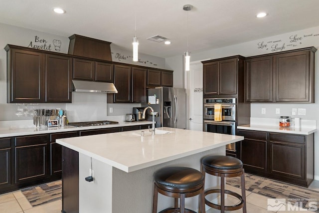 2449 Butte Creek Dr, Sparks, NV 89436 - kitchen featuring under cabinet range hood, appliances with stainless steel finishes, a sink, dark brown cabinets, and light tile patterned floors