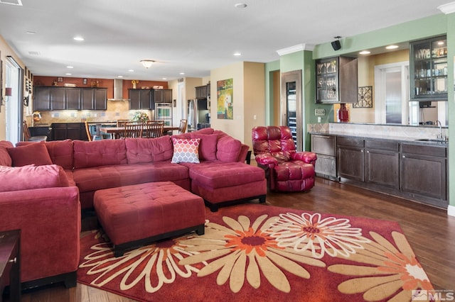 living room with dark wood-style flooring, recessed lighting, and bar area