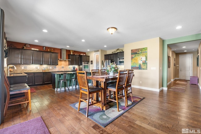 dining room with dark wood finished floors, baseboards, and recessed lighting