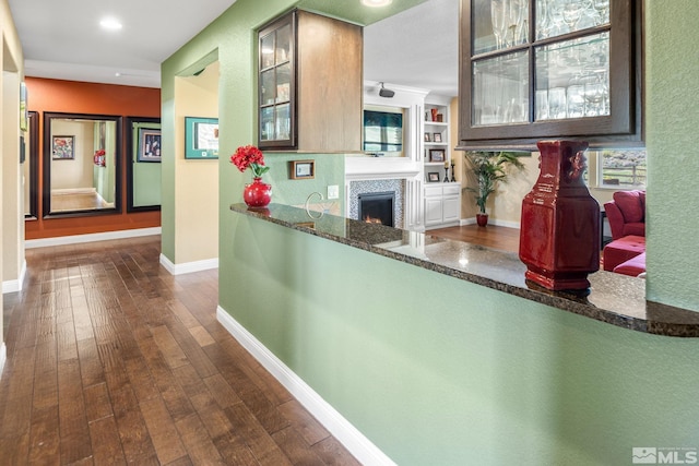 hallway featuring dark wood-style flooring, baseboards, and recessed lighting