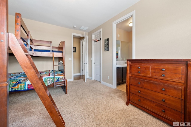 bedroom featuring light colored carpet, connected bathroom, and baseboards