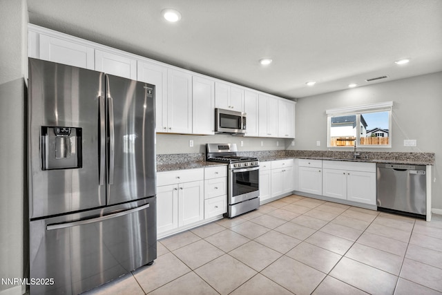 8853 Finnsech, Reno, NV 89506 - kitchen featuring appliances with stainless steel finishes, white cabinetry, light tile patterned floors, and recessed lighting