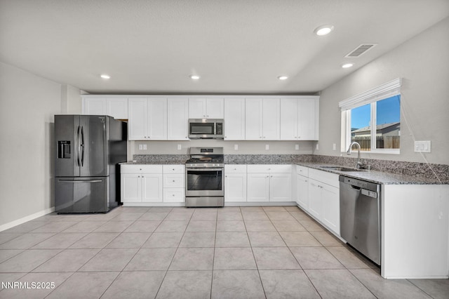 8853 Finnsech, Reno, NV 89506 - kitchen featuring stainless steel appliances, light stone counters, white cabinetry, recessed lighting, and light tile patterned floors