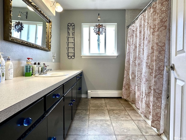 full bath with a baseboard heating unit, healthy amount of natural light, vanity, and baseboards