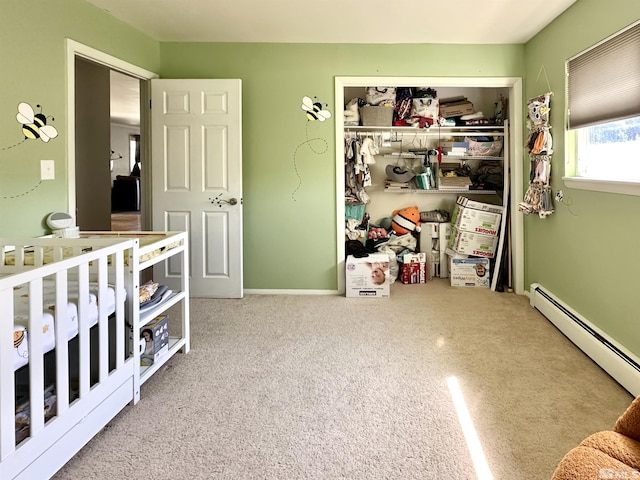 bedroom featuring a baseboard heating unit, a closet, and carpet floors