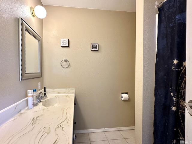 bathroom featuring tile patterned flooring, vanity, and baseboards