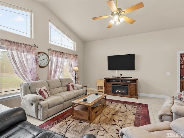 137 Desert Lakes Dr, Fernley, NV 89408 - living room featuring tile patterned floors, baseboards, a ceiling fan, and a warm lit fireplace