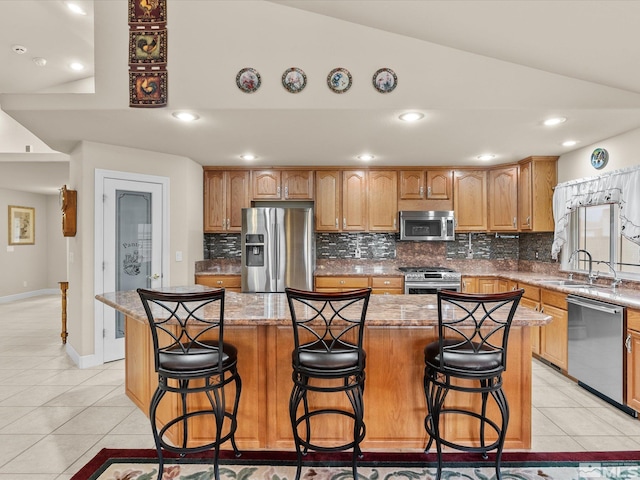 137 Desert Lakes Dr, Fernley, NV 89408 - kitchen featuring stainless steel appliances, a sink, tasteful backsplash, light tile patterned flooring, and lofted ceiling