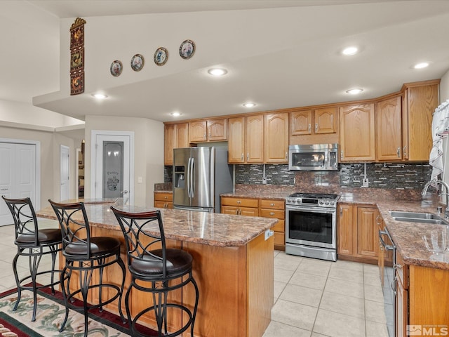 137 Desert Lakes Dr, Fernley, NV 89408 - kitchen featuring stainless steel appliances, a sink, tasteful backsplash, light tile patterned floors, and a breakfast bar