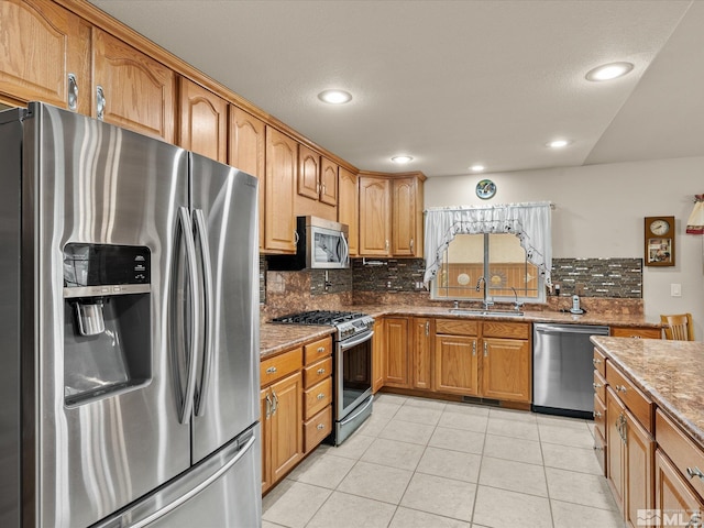 137 Desert Lakes Dr, Fernley, NV 89408 - kitchen with appliances with stainless steel finishes, a sink, backsplash, light tile patterned floors, and stone countertops
